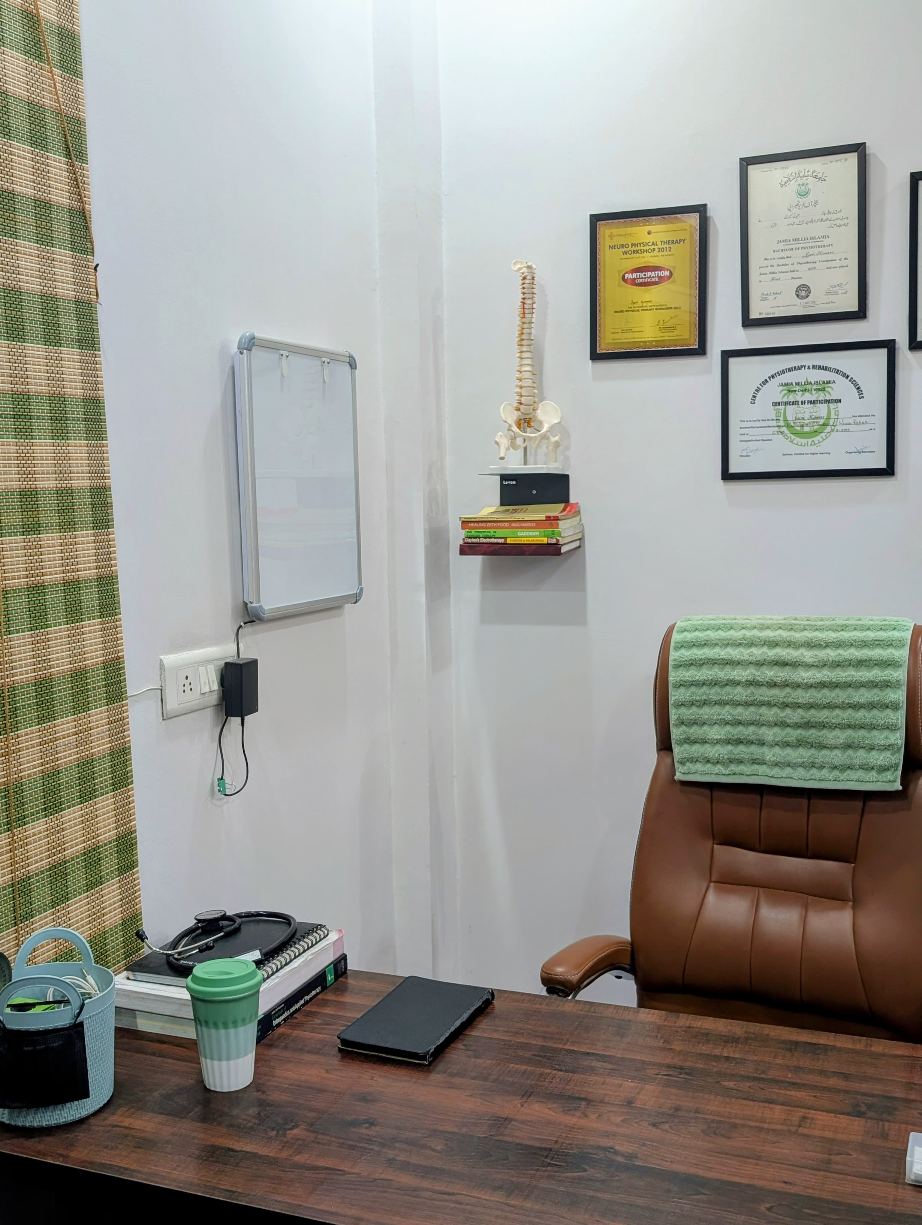 Consultation desk, qualifications and spine model at Trinay clinic